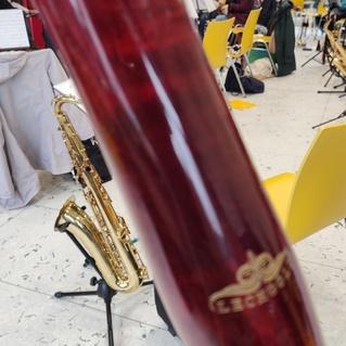 Nahaufnahme eines Fagottrohrs mit einem Saxophon im Hintergrund in einem Probenraum.