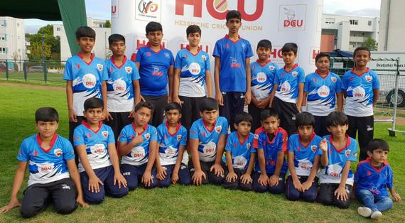Gruppenfoto von Jugendspielern der Hessischen Cricket Union in blauen Trikots auf einem Rasenplatz.