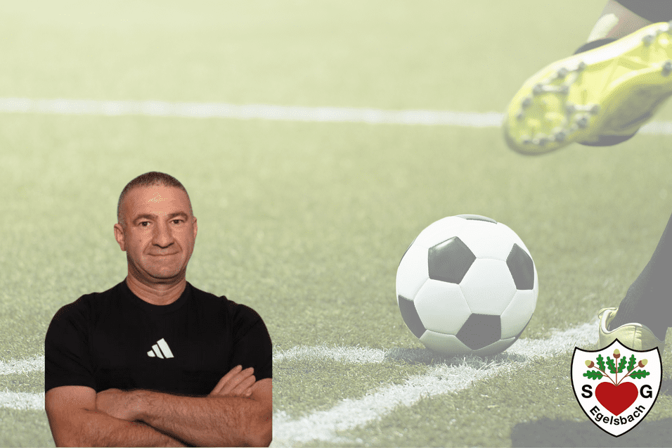 Portrait eines Mannes im schwarzen Sportshirt, neben einem Fußball auf einem Platz mit grünem Rasen.