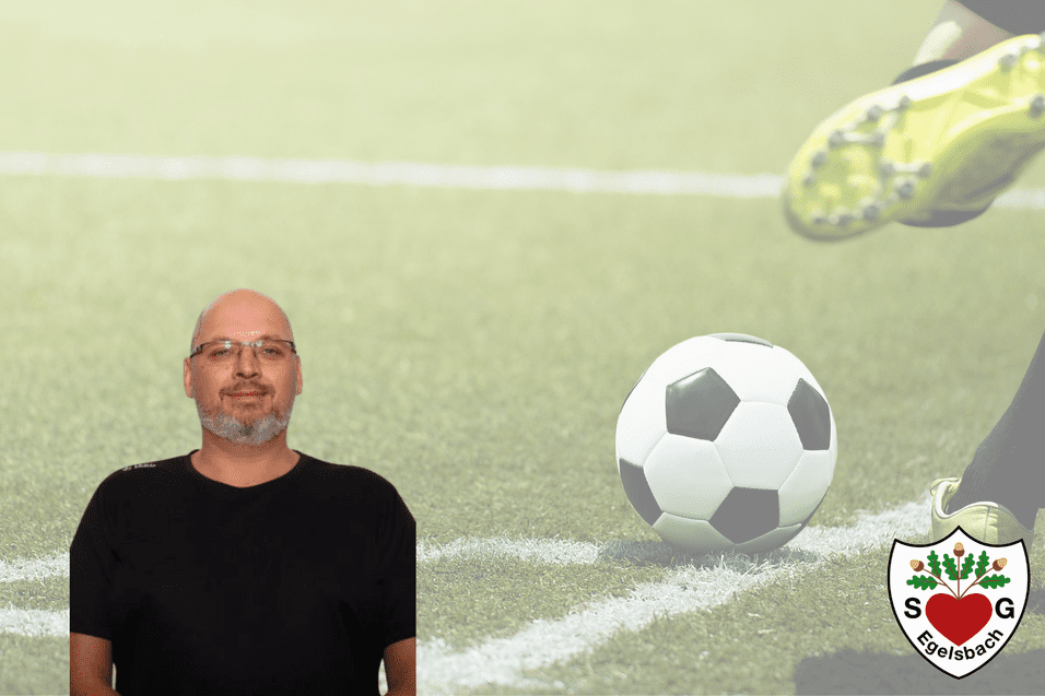 Mann mit Brille steht vor verschwommenem Fußballfeld, ein Fußball rollt vor ihm. Club-Logo unten rechts.