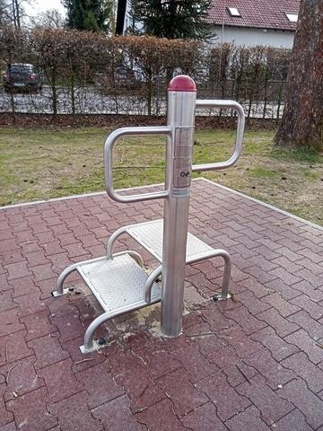Fitnessger&auml;t im Freien mit rutschsicheren Tritten und Haltegriffen auf einem gepflasterten Untergrund.